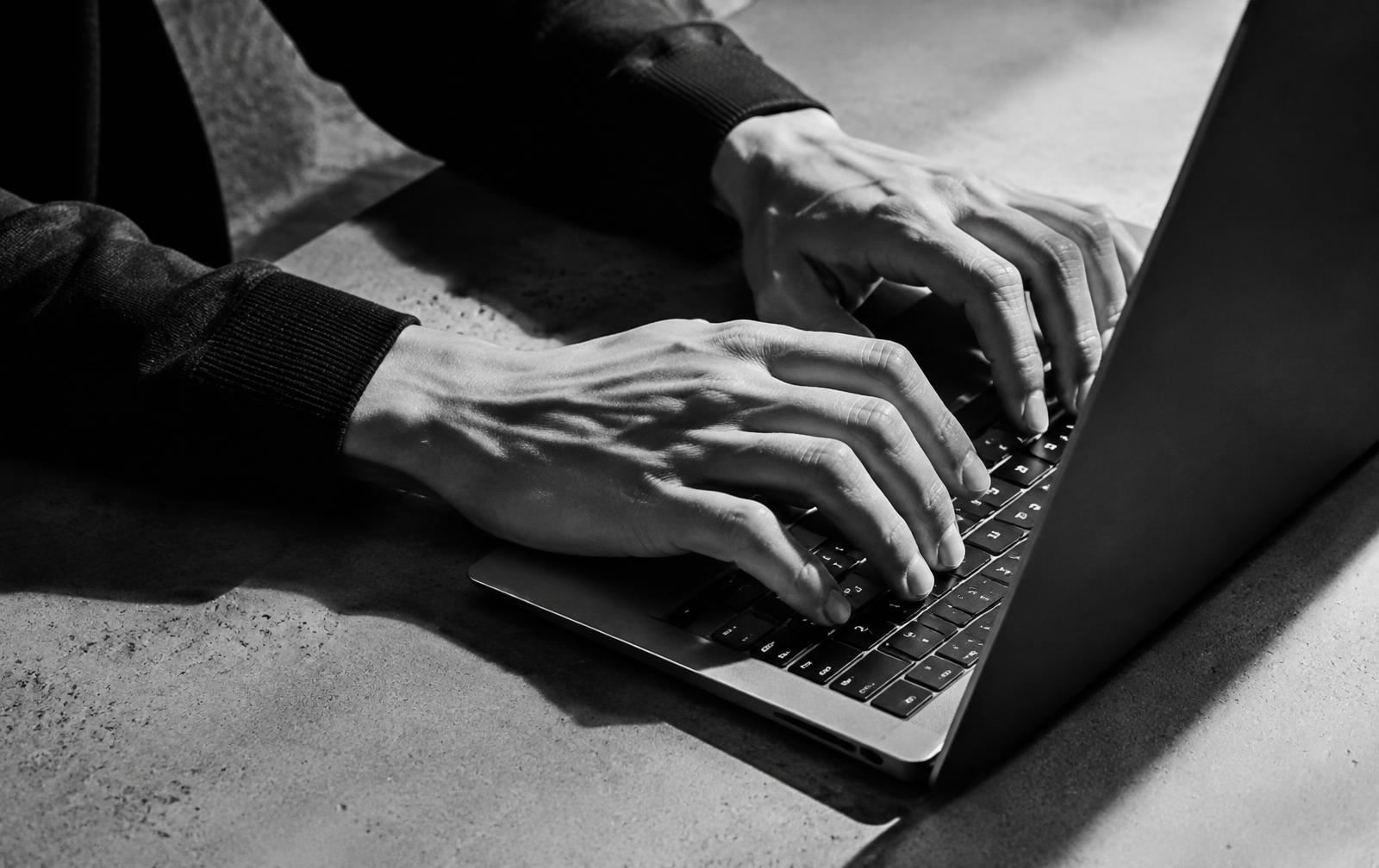 Mains tapant sur un ordinateur portable, photo noir et blanc